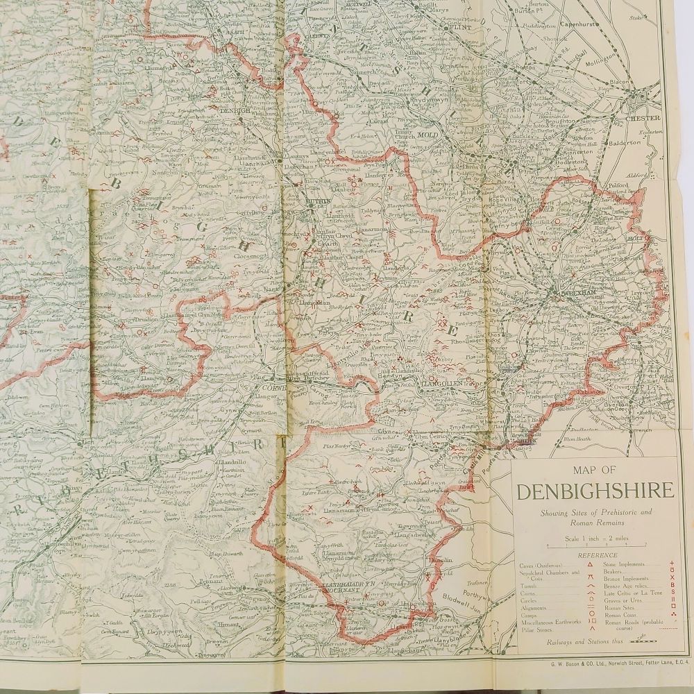 Prehistoric and Roman Remains of Denbighshire Davies (5)a : A large, detailed, multi-folding color map of Denbighshire by G.W. Bacon and Co., featuring a red border and specific symbol references for prehistoric caves, camps, and Roman roads.