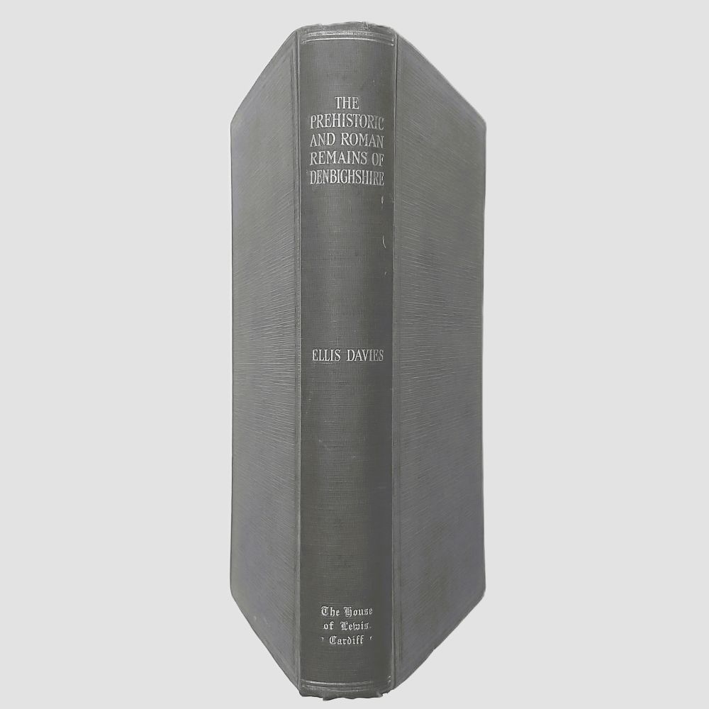 Prehistoric and Roman Remains of Denbighshire Davies (6)a Standing spine view of the book bound in dark green cloth, showing legible silver or white stamped lettering reading "THE PREHISTORIC AND ROMAN REMAINS OF DENBIGHSHIRE", "ELLIS DAVIES", and the publisher logo at the base.