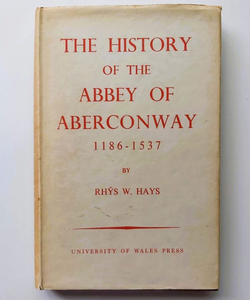 History of the Abbey of Aberconwway Hays (2) Front view of a cream paper dust jacket with bold red lettering reading "THE HISTORY OF THE ABBEY OF ABERCONWAY 1186-1537 BY RHYS W. HAYS"
