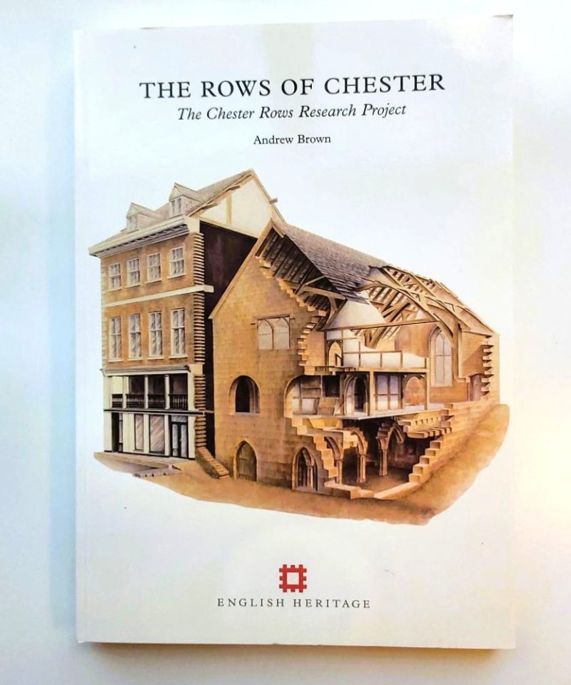 Front cover of the softback book "The Rows of Chester: The Chester Rows Research Project" by Andrew Brown, showing an intricate color isometric cutaway drawing of medieval undercrofts and timber-framed buildings above the English Heritage logo.